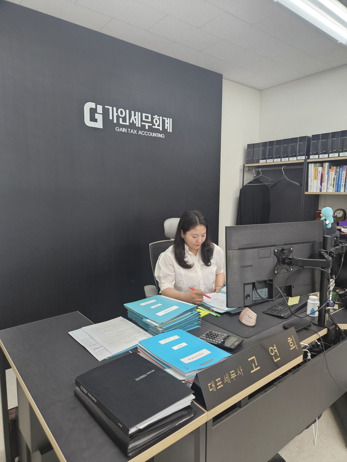 '대표세무사 고연희' 명패가 놓인 책상에서 업무 중인 모습